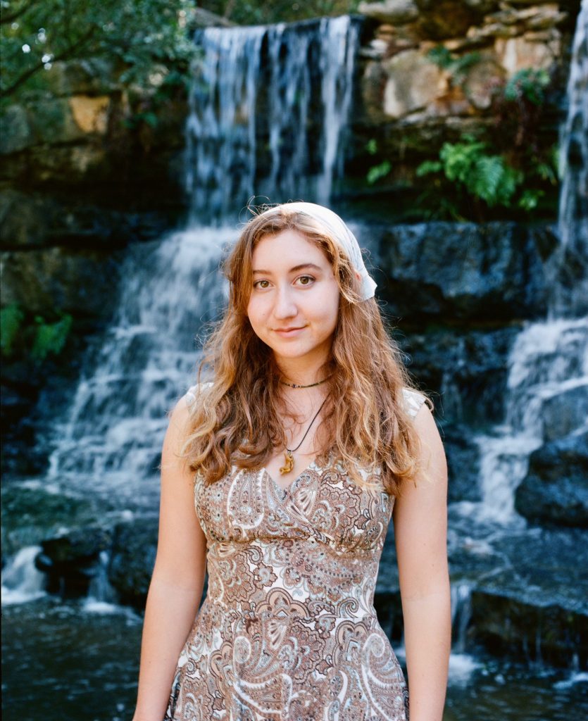 Olivia Gray stands in front of a waterfall